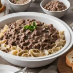 Ground beef cooking in a skillet with onions and garlic.