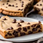 Close-up of a slice of cookie cake showing its chewy texture and chocolate chips.
