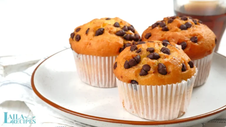 Freshly baked chocolate chip muffins on a cooling rack.